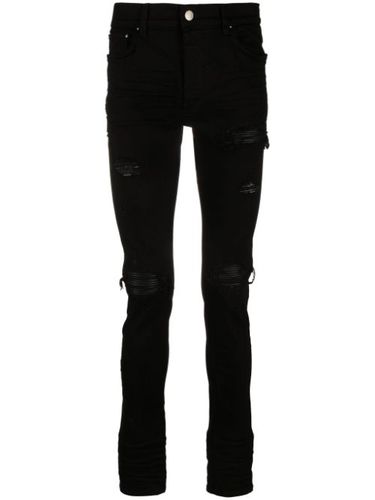 Jean MX1 skinny à effet usé - AMIRI - Modalova