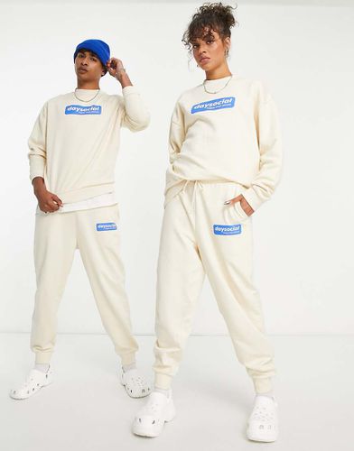 ASOS Daysocial - Pantalon de jogging d'ensemble décontracté unisexe avec logo écusson imprimé - Écru et bleu - Asos Design - Modalova