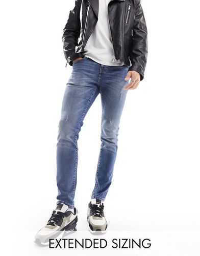 Jean skinny avec abrasions - moyen délavé - Asos Design - Modalova