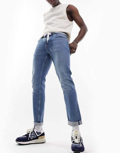 Jean slim stretch en jean surpiqué - Délavage moyen - Asos Design - Modalova