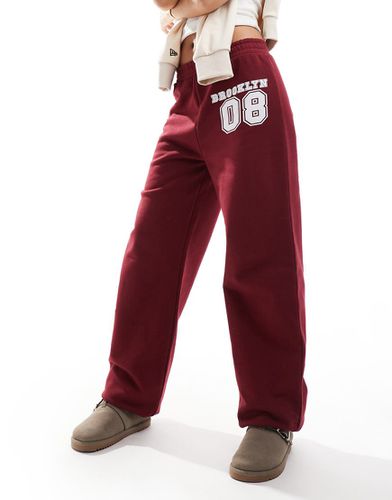 Pantalon de jogging resserré aux chevilles avec appliqué numéro - Bordeaux - Asos Design - Modalova