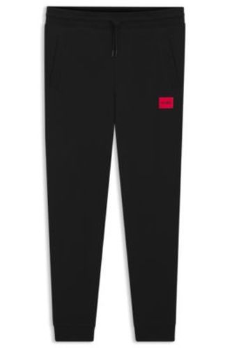 Bas de survêtement en molleton de coton avec étiquette logo rouge - HUGO - Modalova